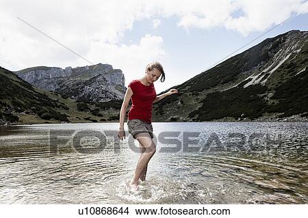 Woman standing in still lake View Large Photo Image Picture - Woman standing in still lake. Fotosearch