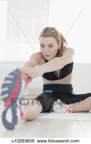Woman stretching at home View Large Photo Image Stock Photo - Woman stretching at home. Fotosearch