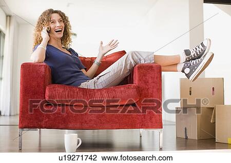 Woman talking on cell phone in armchair View Large Photo Image Stock Image - Woman talking on cell phone in armchair. Fotosearch