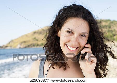 Woman talking on cell phone on beach View Large Photo Image Stock Photo - Woman talking on cell phone on beach. Fotosearch