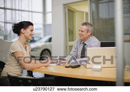 Stock Photo - Woman talking with car salesman. Fotosearch