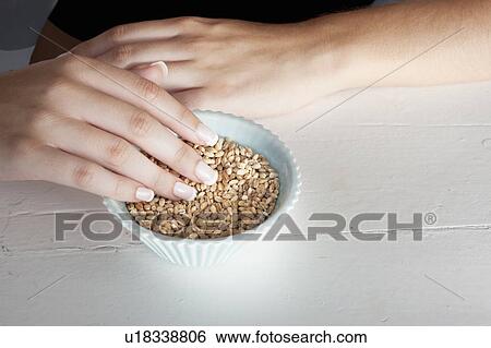Stock Photograph - Woman touching bowl of grains. Fotosearch