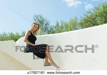 Woman using laptop on steps outdoors View Large Photo Image Stock Image - Woman using laptop on steps outdoors. Fotosearch