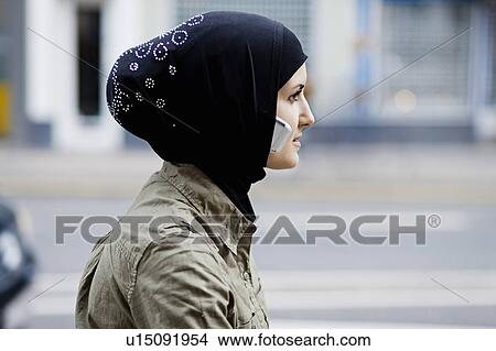 Woman with cell phone in headscarf View Large Photo Image Picture - Woman with cell phone in headscarf. Fotosearch