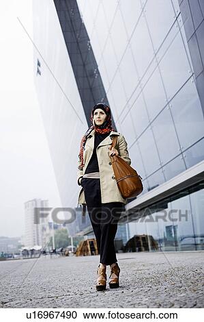 Stock Image - Woman with cell phone in headscarf. Fotosearch