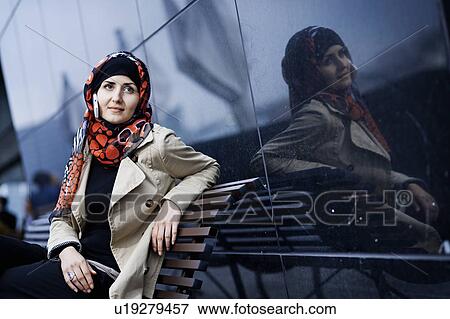 Stock Photo - Woman with cell phone in headscarf. Fotosearch