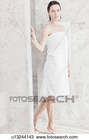 Stock Image - Woman wrapped in towel in bathroom . Fotosearch