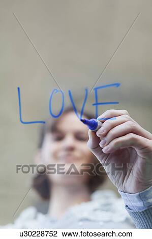 Stock Image - Woman writing ’love’ on glass. Fotosearch