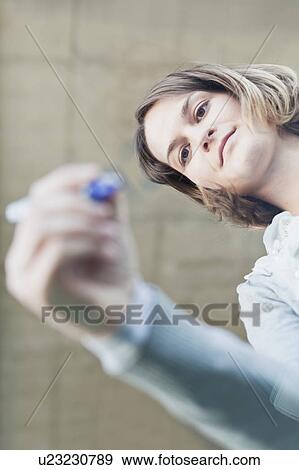 Stock Photo - Woman writing on glass with marker. Fotosearch
