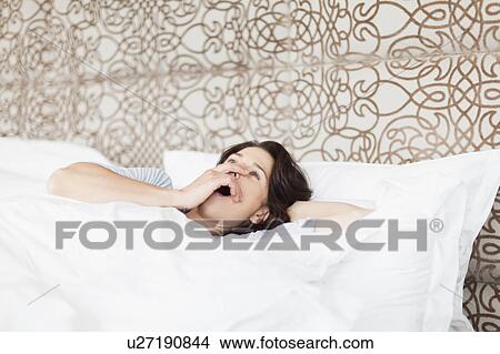 Woman yawning in bed View Large Photo Image Picture - Woman yawning in bed. Fotosearch