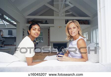 Stock Photo - Women relaxing in living room. Fotosearch