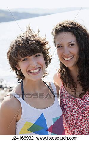 Stock Image - Women smiling together outdoors. Fotosearch