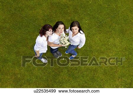 Women standing on grass together View Large Photo Image Stock Photo - Women standing on grass together. Fotosearch