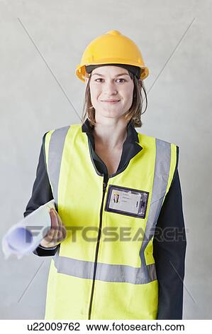 Worker carrying blueprints on site View Large Photo Image Stock Image - Worker carrying blueprints on site. Fotosearch