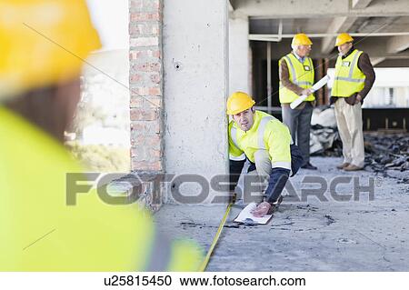 Worker measuring space on site View Large Photo Image Stock Image - Worker measuring space on site. Fotosearch