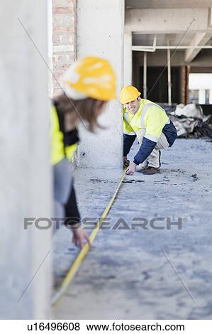 Stock Photo - Worker measuring space on site. Fotosearch
