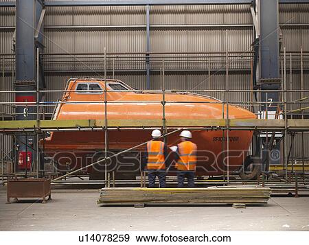 Workers examining ship components View Large Photo Image Stock Photo - Workers examining ship components. Fotosearch