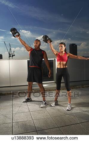 Athletes exercising together on rooftop View Large Photo Image Stock Image - Athletes exercising together on rooftop. Fotosearch