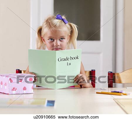 Stock Photography - Bored girl doing homework at desk. Fotosearch