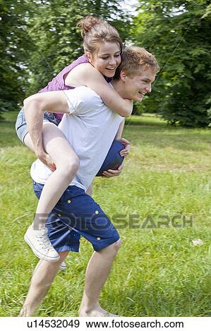 Stock Photo - Boy carrying girlfriend piggyback. Fotosearch
