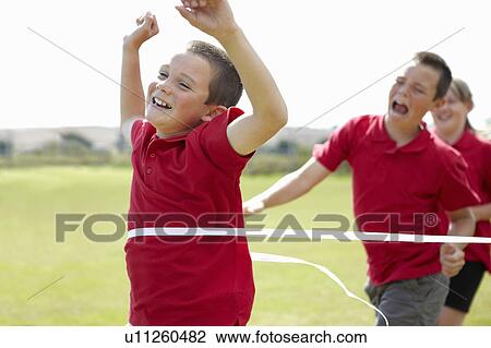 Boy cheering and crossing finish line View Large Photo Image Stock Image - Boy cheering and crossing finish line. Fotosearch