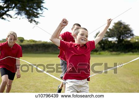Stock Photo - Boy cheering and crossing finish line. Fotosearch