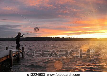 Boy fishing with net in lake View Large Photo Image Stock Image - Boy fishing with net in lake. Fotosearch