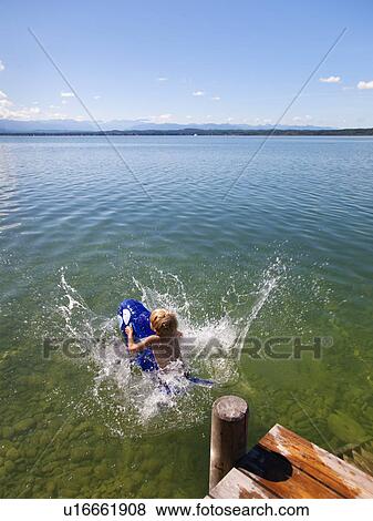 Boy floating in lake with toy whale View Large Photo Image Stock Photo - Boy floating in lake with toy whale. Fotosearch
