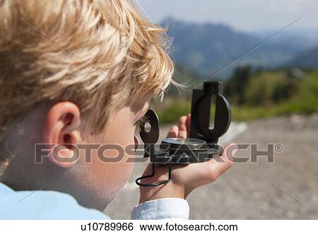 Boy using compass outdoors View Large Photo Image Stock Photograph - Boy using compass outdoors. Fotosearch