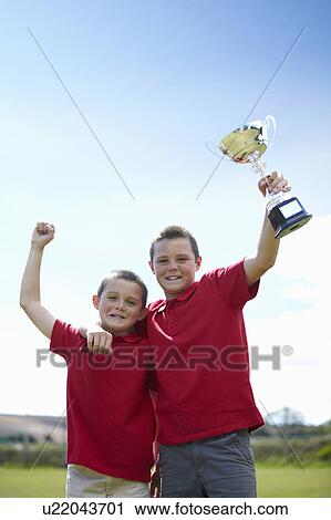 Boys cheering with trophy outdoors View Large Photo Image Stock Image - Boys cheering with trophy outdoors. Fotosearch