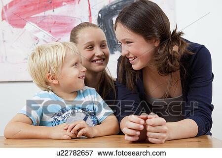 Brother and sisters at table View Large Photo Image Stock Photo - Brother and sisters at table. Fotosearch
