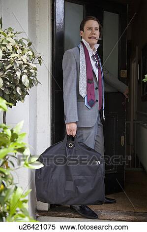 Stock Photography - Businessman carrying luggage indoors. Fotosearch