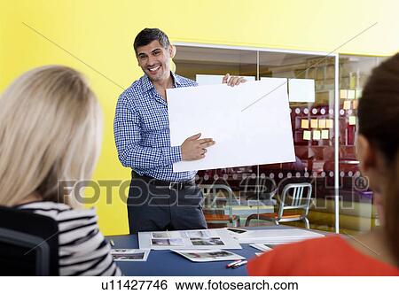 Stock Photograph - Businessman holding blank card. Fotosearch