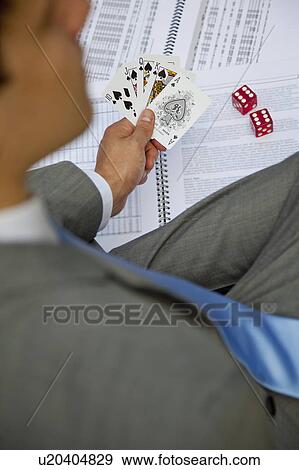 Stock Photo - Businessman playing with cards and dice. Fotosearch