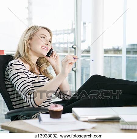 Stock Image - Businesswoman talking on cell phone. Fotosearch