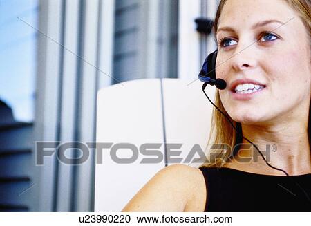 Businesswoman talking on headset View Large Photo Image Stock Image - Businesswoman talking on headset. Fotosearch