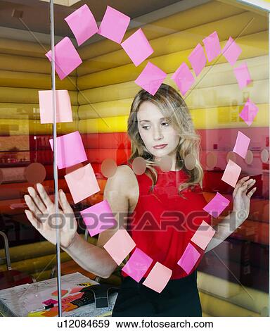 Stock Photo - Businesswomen making heart with notes. Fotosearch