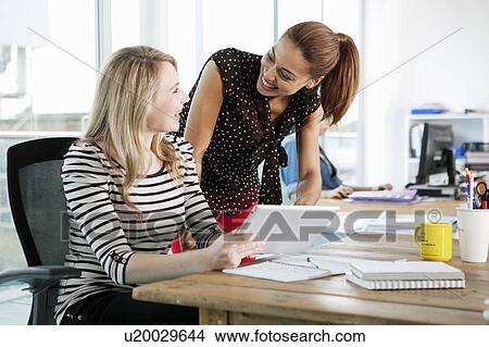 Picture - Businesswomen using digital tablet. Fotosearch