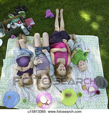 Stock Photography - Children laying on picnic blanket. Fotosearch