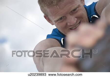 Stock Image - Close up of athlete stretching outdoors. Fotosearch