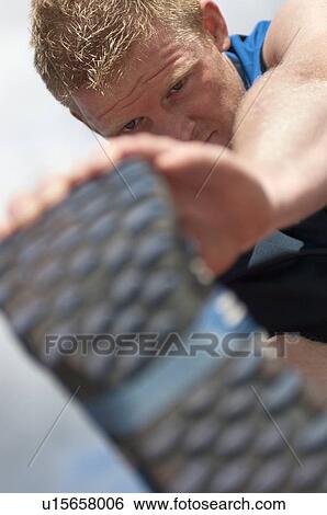 Stock Photograph - Close up of athlete stretching outdoors. Fotosearch