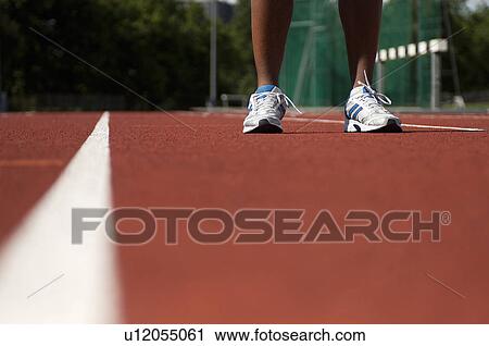 Stock Image - Close up of athlete's feet on track. Fotosearch