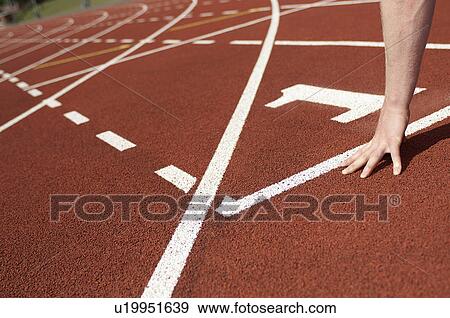 Stock Photo - Close up of athlete's hand on track. Fotosearch