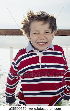 Stock Image - Close up of boy grimacing. Fotosearch