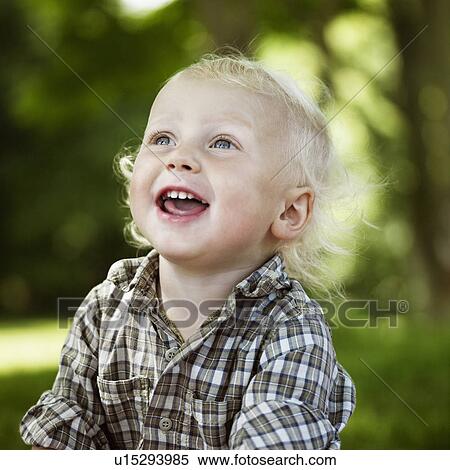 Stock Photography - Close up of boy laughing outdoors. Fotosearch