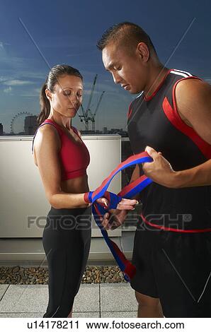 Coach wrapping woman's hands on rooftop View Large Photo Image Stock Image - Coach wrapping woman's hands on rooftop. Fotosearch