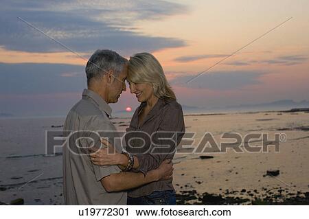 Couple hugging at sunset View Large Photo Image Stock Image - Couple hugging at sunset. Fotosearch