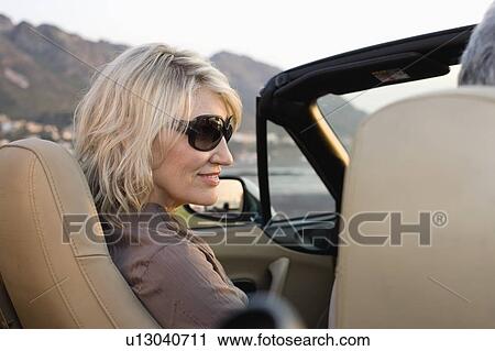 Couple in convertible admiring coastline View Large Photo Image Stock Image - Couple in convertible admiring coastline. Fotosearch