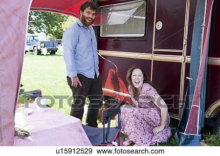 Couple laughing outside trailer View Large Photo Image Stock Photo - Couple laughing outside trailer. Fotosearch
