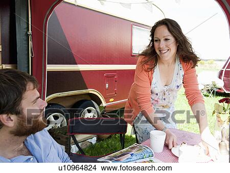 Picture - Couple picnicking outside trailer. Fotosearch